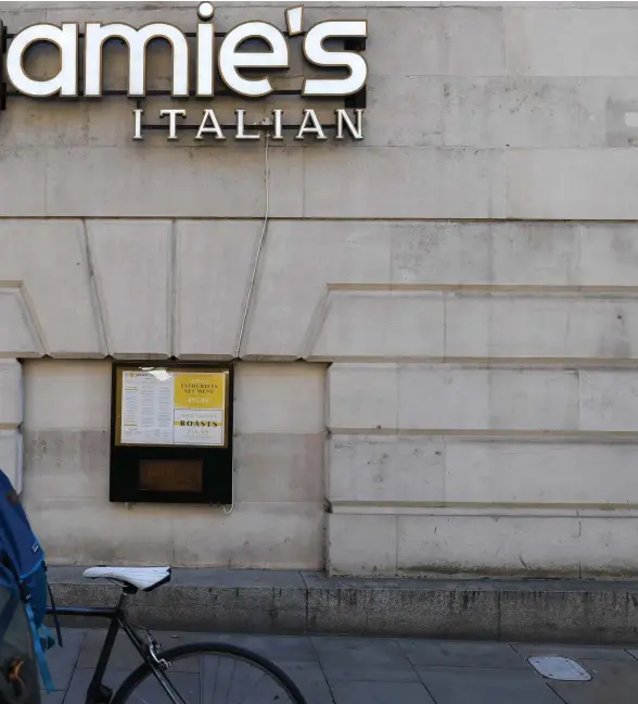  ?? Foto: Peul ellis/lehtikuva-afP ?? Fotgängare passerar en stängd Jamie’s Italian-restaurang i Manchester.