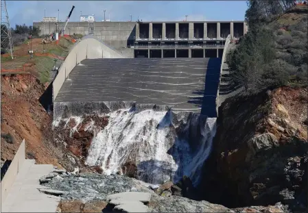  ?? RICH PEDRONCELL­I — THE ASSOCIATED PRESS, FILE ?? Above: Water flows down the Oroville Dam’s crippled spillway in Oroville on Feb. 28, 2017. Americans wondering whether a nearby dam could be dangerous can look up the condition and hazard ratings of tens of thousands of dams nationwide using an online database run by the federal government. But they won’t find the condition of Oroville Dam, which underwent a $1billion makeover after its spillway failed.