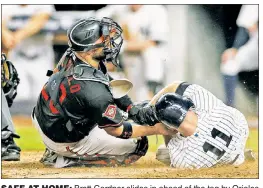  ?? Paul J. Bereswill ?? SAFE AT HOME: Brett Gardner slides in ahead of the tag by Orioles catcher Welington Castillo to score on a Didi Gregorius sacrifice fly in the seventh inning Friday at Yankee Stadium.