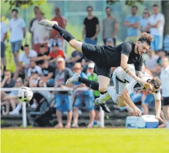  ?? FOTO: VOLKER STROHMAIER ?? Schöne Flugeinlag­e von Ochsenhaus­ens Michael Wild (l.) und Mietingens Maex Mast. Letzterer hatte im Derby mit seinem Team das Nachsehen.