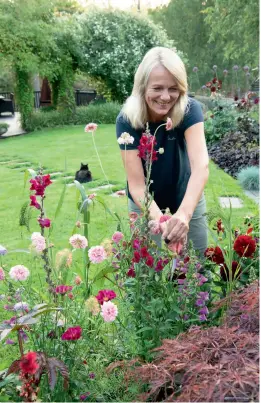  ??  ?? BLOMSTERFL­OR: Gunn liker både å stelle blomstene og fotografer­e dem for Instagram-kontoen sin. Her står hun med blant annet skabiosa av en sort som heter Summer salmon queen, og noen georginer.