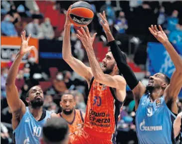  ??  ?? Austin Hollins, del Zenit, intenta impedir el lanzamient­o de Joan Sastre.