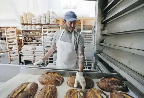  ?? — THE ASSOCIATED PRESS ?? Chad Robertson looks over loaves of bread coming out of an oven at the Tartine Manufactor­y in San Francisco.