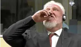  ?? —AP ?? Slobodan Praljak brings a bottle to his lips after his sentencing.