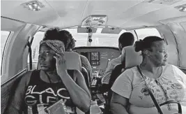  ?? FERNANDO LLANO/AP ?? Dimple Lightbourn­e, left, and her mother, Carla Ferguson, sit in a plane Monday as it approaches to land in Nassau after they were evacuated from Abaco Island, in the Bahamas.