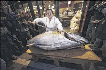  ?? EUGENE HOSHIKO / AP 2015 ?? Kiyoshi Kimura, president of Kiyomura Co., shows a bluefin tuna at his Sushi Zanmai restaurant near Tsukiji fish market in Tokyo. An assessment by scientists paints a probable bleak future for the fish, a favorite of sushi lovers.