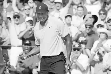  ?? CURTIS COMPTON/TNS ?? Tiger Woods and the gallery react as he sinks his putt on the 18th green to check in at 5-under in Thursday’s opening round.