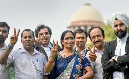  ?? PTI ?? Nirbhaya’s parents show victory sign after the Supreme Court’s verdict in New Delhi on Monday. —