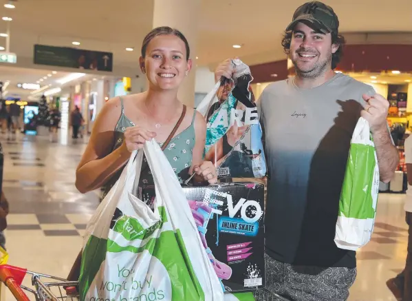  ?? Picture: STEWART McLEAN ?? HAPPY SHOPPERS: Bentley Park couple Nikita and Darryn Born found some bargains at Stockland Cairns shopping centre in Earlville on Boxing Day.