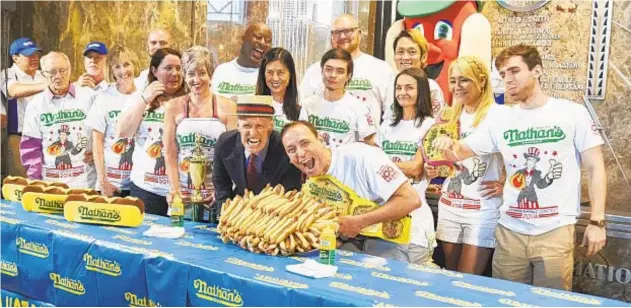  ?? JAMES KEIVOM/NEW YORK DAILY NEWS ?? Champion Joey Chestnut and fellow frank fans get pumped up for world “Famous” chow-down Wednesday at Coney Island. Below, Chestnut and Carmen Cincotti have friendly face-off.