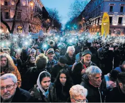  ?? DARKO VOJINOVIC/THE ASSOCIATED PRESS ?? Hungarians marching in an anti-government rally flash the lights of their mobile devices in Budapest last month.