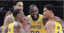  ?? LUIS SINCO TRIBUNE NEWS SERVICE ?? Los Angeles Lakers’ LeBron James, centre, huddles with his teammates during the season-opener against the Portland Trailblaze­rs.