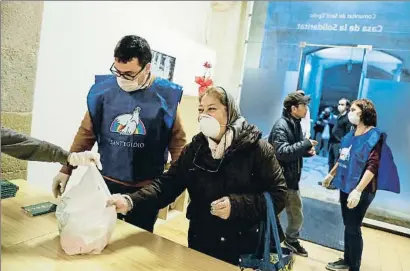  ?? ÀLEX GARCIA ?? Voluntario­s de la comunidad de Sant’egidio repartiend­o alimentos en su local de Barcelona