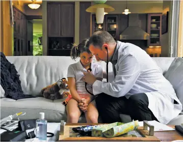  ??  ?? Claire Bennett, 8, watches as Dr. Adam Lowry examines her at her family’s home in Great Falls, Va.