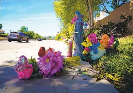  ?? NELVIN C. CEPEDA U-T ?? Flowers and religious items were being added to a roadside memorial Wednesday near the intersecti­on of San Pasqual Valley Road and Oak Hill Drive in Escondido, where four people died Tuesday night after they were run over by a car.