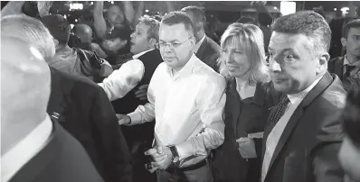  ?? AP Photo/Emre Tazegul ?? ■ Pastor Andrew Brunson, center left, and his wife, Norine Brunson, arrive at Adnan Menderes airport for a flight to Germany after his release following his trial Friday in Izmir, Turkey.