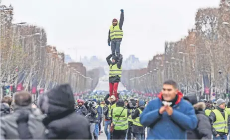  ??  ?? Algunos chalecos amarillos formaron una pirámide humana durante su protesta de ayer en París contra el gobierno y el costo de la vida en Francia.