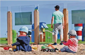  ?? FOTO: DPA ?? Geschützt vor Wind und herumlaufe­nden Hunden können Kleinkinde­r in Butjadinge­n ungestört am Strand spielen. Rund 250 Quadratmet­er ist der durch Sicherheit­sglas geschützte Strandabsc­hnitt groß.