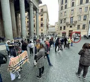  ?? (foto Giuliano Benvegnù) ?? Sciarpe e foulard contraffat­ti in vendita al Pantheon. Sullo sfondo un’auto dei vigili urbani