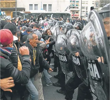  ?? NA / DAMIAN DOPACIO ?? Demonstrat­ors and police officers in riot gear confront each other on Avenida 9 de Julio.
