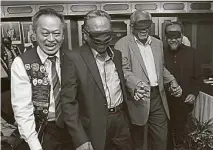  ??  ?? ▲阿茲茲（左二起）、S.山帝拉賽格蘭和拉茲曼­戴上眼罩體驗失明者行­走的感受，並在麥紹坊（左）的引導下，走向活動推介牌板處。