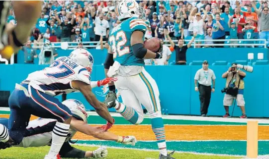  ?? MICHAEL REAVES/GETTY-AFP ?? Anatomy of the final play: (Clockwise from top left) The Dolphins’ Kenny Stills looks to lateral a pass from Ryan Tannehill to a teammate, spins and tosses it to DeVante Parker, who relays to Kenyan Drake, who races the final 52 yards to complete a 69-yard touchdown on the final play of the game as the Dolphins pulled off a 34-33 victory over the Patriots.