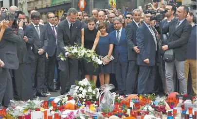  ??  ?? O rei da Espanha Felipe VI e a rainha Letizia levaram flores ao local do atentado terrorista, em Barcelona