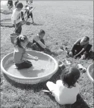  ?? Photo by Susan Holland ?? After several rainy days, the weather cooperated perfectly for Glenn Duffy Elementary School’s annual Buddy Day. The warm, sunny day made gathering marbles from a wading pool an inviting activity. This young lady was enjoying getting good and wet.