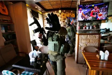  ??  ?? Israeli soldiers search inside a restaurant during a raid in the West Bank city of Ramallah. —A FP photo