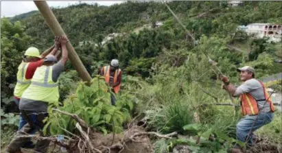  ?? DIGITAL FIRST MEDIA FILE PHOTO ?? In this file photo, municipal workers install a new post to return electricit­y to a home four months after Hurricane Maria hit Puerto Rico. The island continues to recover from the massive storm.