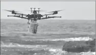  ?? PETER PARKS / AGENCE FRANCE-PRESSE ?? A shark-spotting drone with a safety flotation device attached underneath flies over Bilgola beach north of Sydney on Sunday.