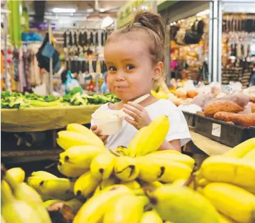  ??  ?? RECORD BENDER: Isabella Watkins, 4, enjoys a banana split at Rusty’s Markets. Picture: JUSTIN BRIERTY