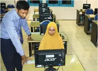  ?? UMAR WIRAHADI/JAWAPOS ?? UJIAN SENDIRI: Regina Putri Al Ghania dan Kepala SMA Muhammadiy­ah 1 Gresik Ainul Yaqin di ruang laboratori­um komputer kemarin.