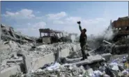  ?? HASSAN AMMAR — ASSOCIATED PRESS ?? A Syrian soldier films the damage to the Syrian Scientific Research Center which was the target of U.S., British and French military strikes in Barzeh, near Damascus, Syria, on Saturday.