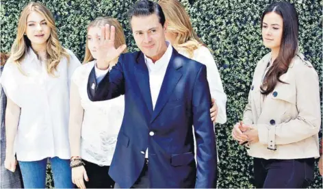  ??  ?? El Presidente de México, Enrique Peña Nieto, saluda junto a sus familiares a los seguidores después de emitir su voto, el domingo, en Ciudad de México.