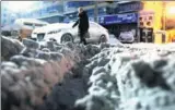  ?? ZHANG WANDE / FOR CHINA DAILY ?? A pedestrian walks on a snow-covered road in Urumqi, Xinjiang Uygur autonomous region, on Thursday. A strong blizzard hit the city on Wednesday.