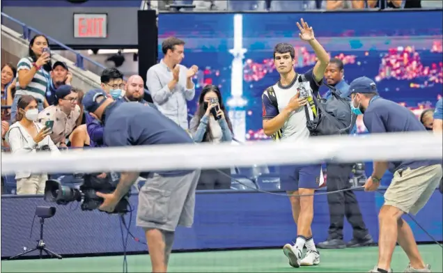  ??  ?? Carlos Alcaraz se despide del público de la pista Arthur Ashe después de retirarse en el segundo set de su partido contra Felix Auger-Aliassime en el US Open.