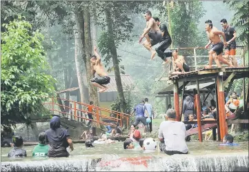  ??  ?? People play with water at Sugai Kemensah in Kuala Lumpur as a respite from the hot weather during the long break. — Bernama photo