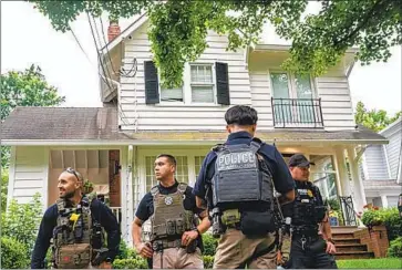  ?? Nathan Howard Getty Images ?? OFFICERS gather outside the Maryland home of Supreme Court Justice Brett M. Kavanaugh on Wednesday after an armed man from Simi Valley was arrested and later charged with attempted kidnapping and murder.