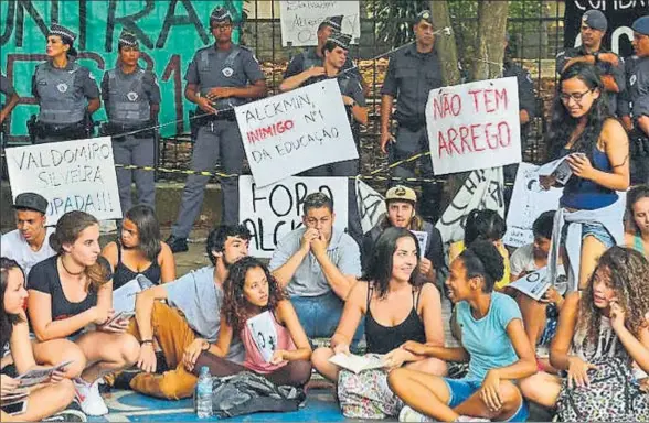  ?? ANDY ROBINSON ?? Varios alumnos de la escuela pública Almaro Cavalcanti conversan bajo la vigilancia de las fuerzas policiales en Río de Janeiro