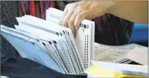  ?? Brynn Anderson Associated Press ?? AN ELECTION worker handles ballots during vote counting for the November election at State Farm Arena in Atlanta.