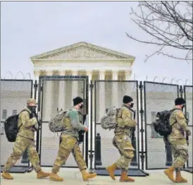  ?? AP ?? Members of the National Guard walk outside of the US Supreme Court, during the impeachmen­t trial of former president Donald Trump at the Capitol in Washington.