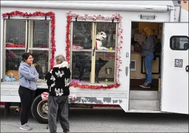  ?? (River Valley Democrat-Gazette/Hank Layton) ?? Vanessa Victoriano (left) and other Fort Smith Animal Haven staff greet visitors Friday to their mobile adoption center at a two-day My Furry Valentine adoption event outside Petco in Fort Smith. Visit nwaonline.com/photo for today’s photo gallery.