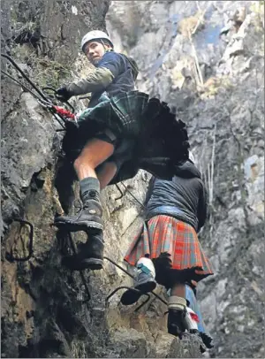  ?? Picture: PA. ?? Kilt-clad climbers make their way up Scotland’s first Via Ferratas, or iron way, which opened yesterday in Kinlochlev­en, near Glencoe.