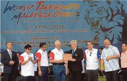  ?? BERNAMA PIC ?? Prime Minister Datuk Seri Najib Razak receiving a black belt certificat­e from World Taekwondo Federation president Dr Choue Chung-won at the World Taekwondo Malaysia Open G1 Championsh­ip 2018 in Putrajaya yesterday.