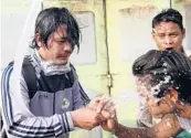  ?? AP ?? People rinse their faces after tear gas was used to disperse a protest Saturday in Mandalay, Myanmar. Security forces also used slingshots and rubber bullets against demonstrat­ors.