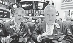  ?? RICHARD DREW AP ?? Traders John Panin, left, and Edward McCarthy on the floor of the New York Stock Exchange on Wednesday.