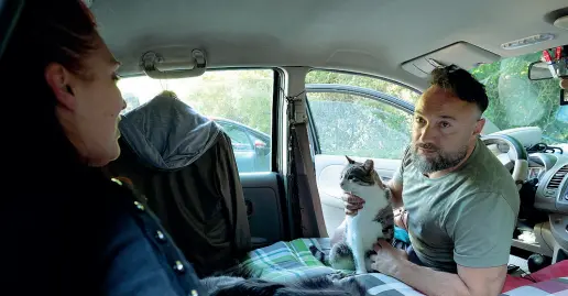  ?? (Foto Rensi) ?? Sulla strada Luigi Esposito e Giuseppina Dalla Bruna dentro alla loro auto parcheggia­ta a Villazzano con uno dei gatti