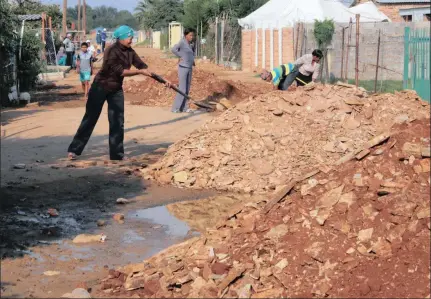  ??  ?? BURY: Residents in Cyntrax Street in Homevalley were yesterday forced take matters into their own hands and flatten the gravel which was dumped by the municipali­ty to cover the sewage soiled road yesterday.
Picture: Soraya Crowie