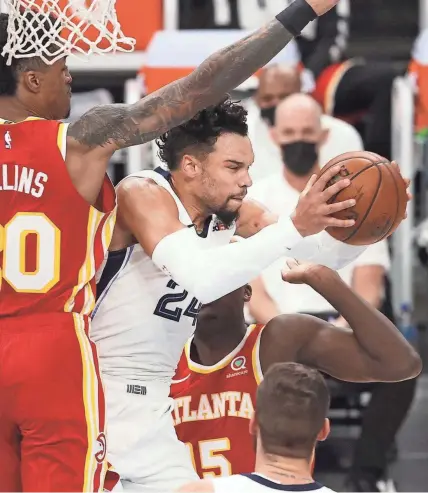  ?? JOE RONDONE/THE COMMERCIAL APPEAL ?? Grizzlies guard Dillon Brooks looks to pass the ball as Atlanta Hawks forward John Collins defends during their preseason game at the Fedexforum last Thursday.